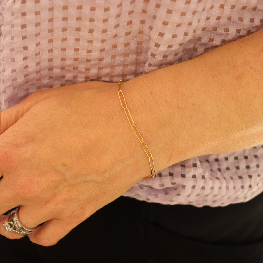 a 9ct gold plain link bracelet on a woman's wrist