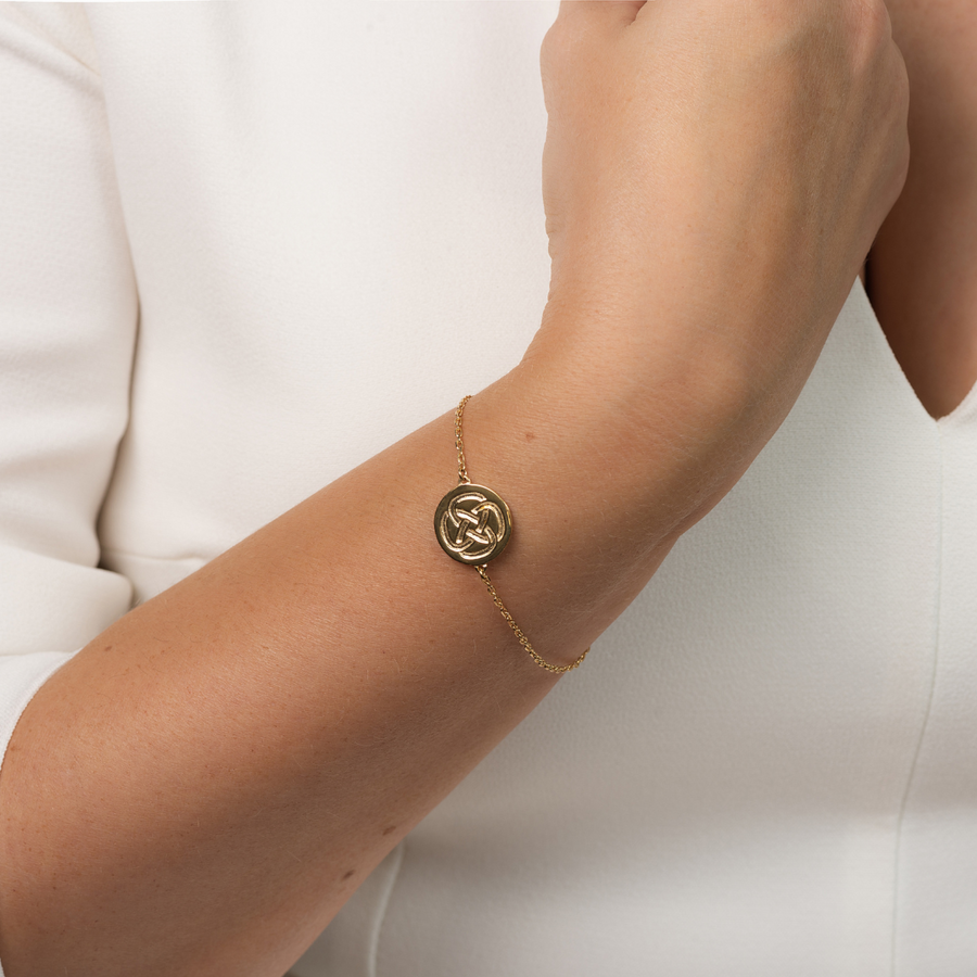 gold plated dara knot symbol bracelet on a women's wrist